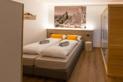 a bed in a room with two pillows on it at Latemar Fiemme Apartments 1 in Tesero