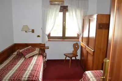 a bedroom with a bed and a window and a chair at Hotel Bosco Verde in Mareson
