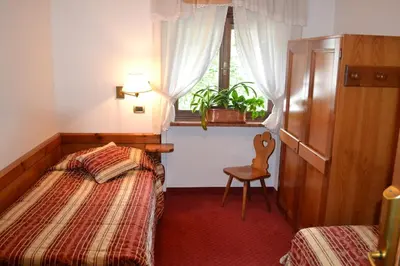 a bedroom with a bed and a window and a chair at Hotel Bosco Verde in Mareson