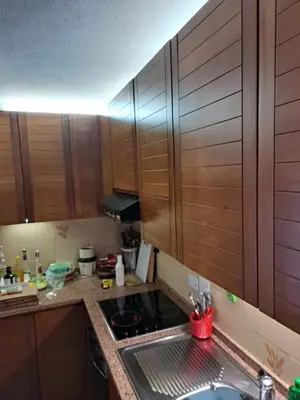 a kitchen with wooden cabinets and a sink at Appartamento 8 Palazzina Maria in Ziano di Fiemme