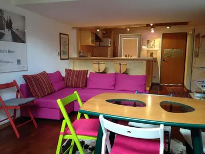 a living room with a purple couch and a table at Casa Similde e Casa Dolasilla in centro in Bolzano