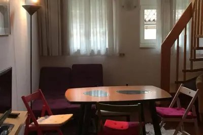 a living room with a table and chairs and a couch at Casa Similde e Casa Dolasilla in centro in Bolzano