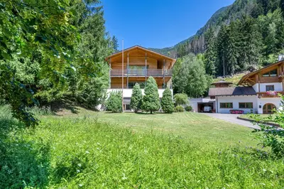 a house in the mountains with a large yard at Apartments Villa Jim in Ortisei