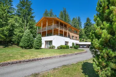 a house with a wooden facade on a road at Apartments Villa Jim in Ortisei
