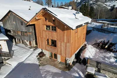 a building with snow on top of it at Maso delle Falesie in Rocca Pietore