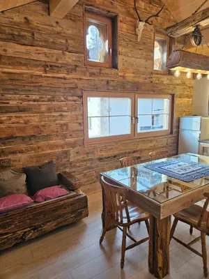 a dining room with a table and a couch at Maso delle Falesie in Rocca Pietore