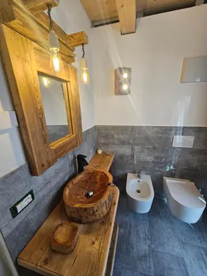 a bathroom with a wooden sink and a toilet at Maso delle Falesie in Rocca Pietore