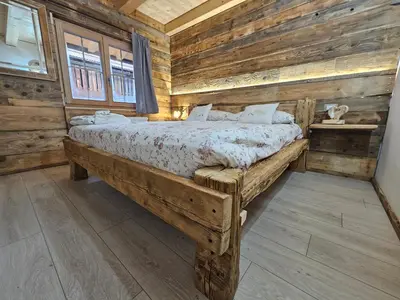 a bedroom with a bed in a log cabin at Maso delle Falesie in Rocca Pietore