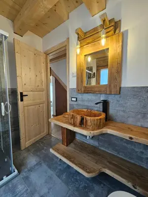 a bathroom with a wooden tub and a mirror at Maso delle Falesie in Rocca Pietore