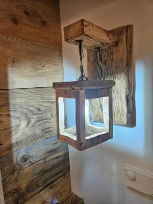 a wooden lantern hanging on a wall at Maso delle Falesie in Rocca Pietore