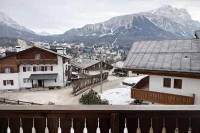 a view of a village with mountains in the background at Val di sopra - Panoramic attic in Cortina dʼAmpezzo