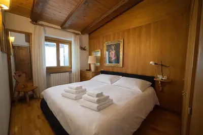 a bedroom with a white bed with towels on it at Val di sopra - Panoramic attic in Cortina dʼAmpezzo