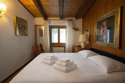 a bedroom with a bed with white towels on it at Val di sopra - Panoramic attic in Cortina dʼAmpezzo