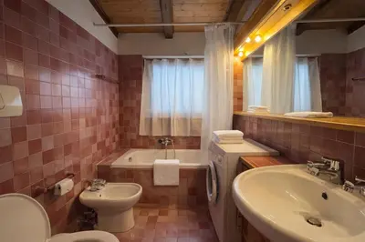 a bathroom with a sink and a toilet and a tub at Val di sopra - Panoramic attic in Cortina dʼAmpezzo