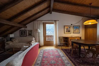 a living room with a couch and a table at Val di sopra - Panoramic attic in Cortina dʼAmpezzo