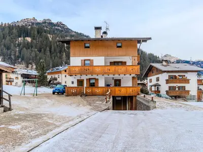 a snow covered road in front of a wooden house at Apartment Cristina by Interhome in Campestrin