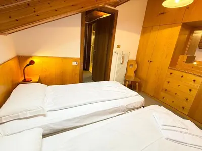 a bedroom with two beds and a mirror at Apartment Roacia-5 by Interhome in Alba di Canazei
