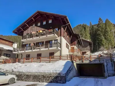 a large house with a balcony and a car in the snow at Apartment Roacia-5 by Interhome in Alba di Canazei