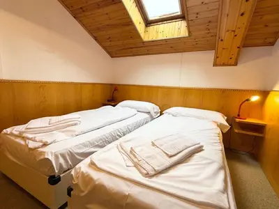 two twin beds in a room with a window at Apartment Roacia-5 by Interhome in Alba di Canazei