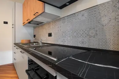 a kitchen with a sink and a counter top at Dolomiapartments - Bosco Fontana 1 in Predazzo
