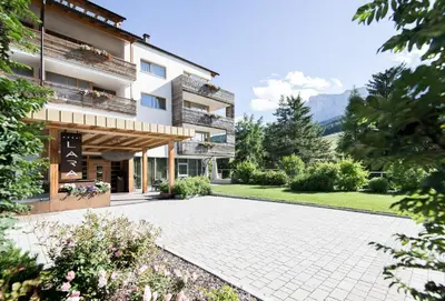 a large building with a courtyard in front of it at Alpine Hotel Ciasa Lara in La Villa