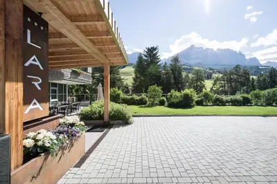 a porch of a house with mountains in the background at Alpine Hotel Ciasa Lara in La Villa