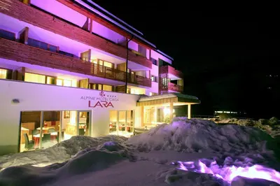 a building with a pile of snow in front of it at Alpine Hotel Ciasa Lara in La Villa