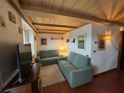 a living room with a couch and a tv at Appartamento Al Settimo Cielo in Tesero