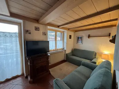 a living room with a couch and a flat screen tv at Appartamento Al Settimo Cielo in Tesero