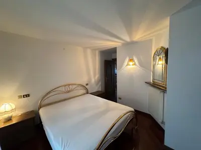 a bedroom with a white bed in a room at Appartamento Al Settimo Cielo in Tesero