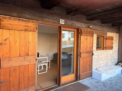 a room with wooden doors and a room with a table at Ca Costanza in Cortina dʼAmpezzo