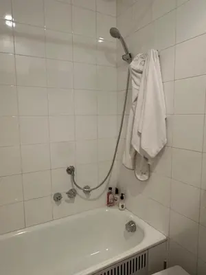 a white bathroom with a tub and a towel at Ca Costanza in Cortina dʼAmpezzo