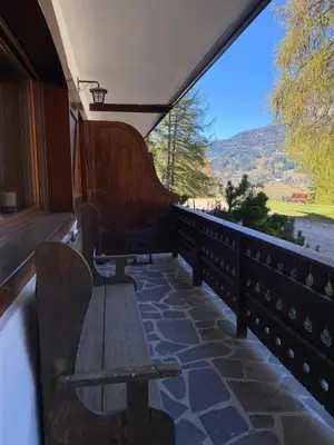 a bench on a balcony with a view of a mountain at Cortina Olympic Alpine Holidays in Cortina dʼAmpezzo