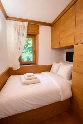 a bedroom with a large bed with a window at Cortina Olympic Alpine Holidays in Cortina dʼAmpezzo