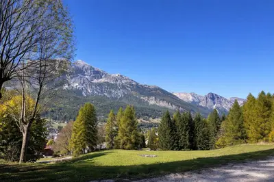 a grassy hill with a mountain in the background at Cortina Olympic Alpine Holidays in Cortina dʼAmpezzo