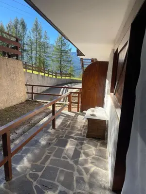 a porch of a building with a bench and a fence at Cortina Olympic Alpine Holidays in Cortina dʼAmpezzo