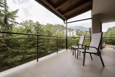 a balcony with chairs and a view of trees at Villa Rosengarten Guesthouse in Merano
