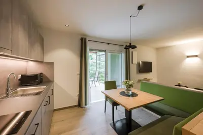 a kitchen with a small table and a kitchen with a dining room at Villa Rosengarten Guesthouse in Merano