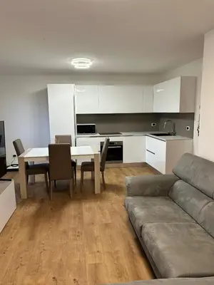 a kitchen and a living room with a table and a couch at Primule 2 Cavareno in Cavareno