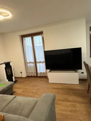 a living room with a large flat screen tv at Primule 2 Cavareno in Cavareno