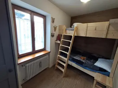 a bunk bed with a ladder in a room at La Casetta del Cervo a Fiori in Predazzo