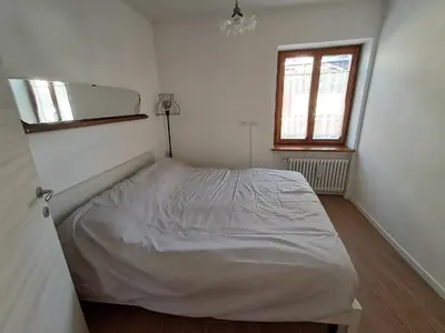 a small bedroom with a bed in the corner at La Casetta del Cervo a Fiori in Predazzo