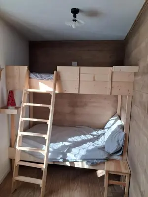 a bunk bed with a ladder in a room at La Casetta del Cervo a Fiori in Predazzo