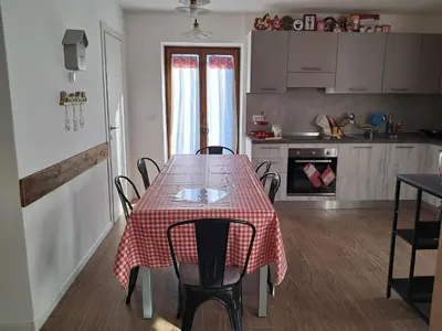 a kitchen with a table with a red checkered table cloth on it at La Casetta del Cervo a Fiori in Predazzo