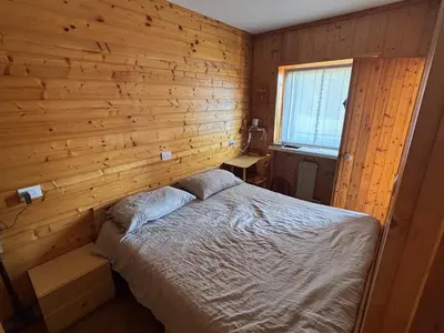 a bedroom with a bed in a wooden wall at Il Nido in Carano
