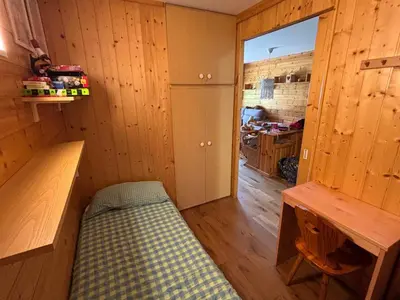 a room with a bed in a room with wooden walls at Il Nido in Carano