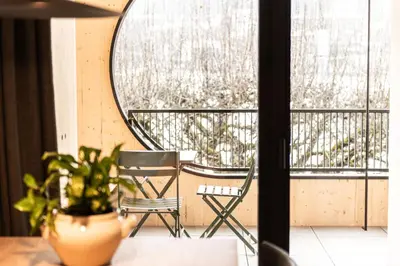 a chair and a mirror on a balcony at Senner Nature Stay in Riscone