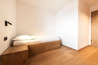 a bedroom with a bed with a wooden platform at Senner Nature Stay in Riscone