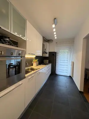 a kitchen with white cabinets and a counter top at Dolomites Home Bolzano in Bolzano