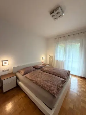a bedroom with a large bed and a window at Dolomites Home Bolzano in Bolzano